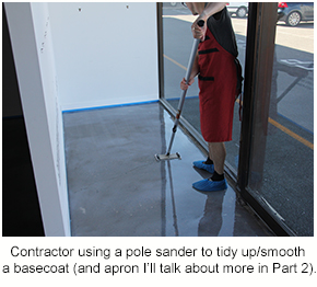 A resin flooring contractor using a pole sander to smooth out protrusions on a basecoat.