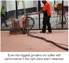 A large grinder grinding a floor that could be hard or soft concrete.
